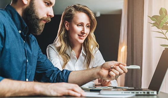 Photo of two people working on a computer